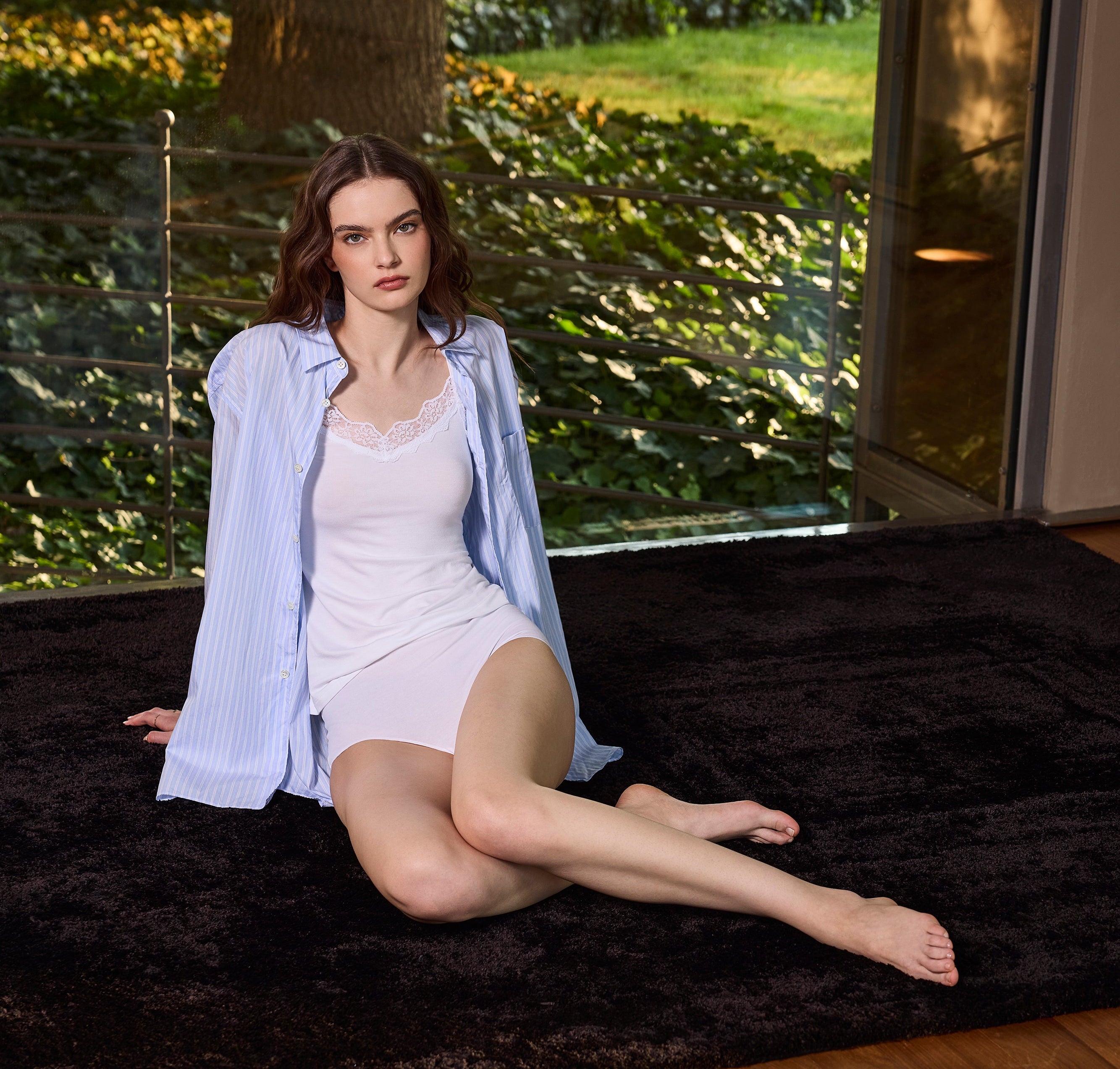 Ragazza che indossa una canotta viscosa con inserto in pizzo sullo scollo a V bianca, uno slip underwear in cotone premium elasticizzato bianco a vita alta.